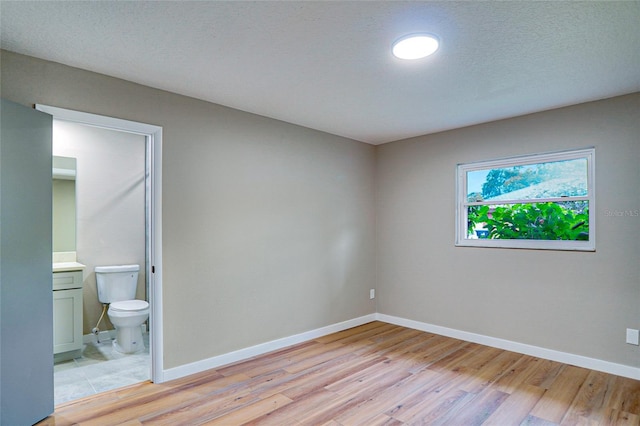 5938 Marlberry Dr, Orlando, FL 32819 - unfurnished bedroom featuring light wood finished floors and connected bathroom