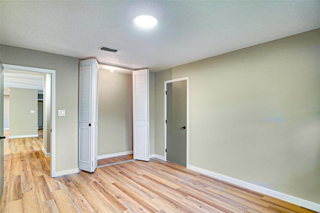 5938 Marlberry Dr, Orlando, FL 32819 - unfurnished bedroom featuring light wood-style floors, a closet, and a textured ceiling