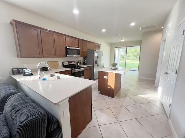 17504 Butterfly Pea Ct, Clermont, FL 34714 - kitchen featuring stainless steel appliances, light countertops, a center island, recessed lighting, and light tile patterned floors