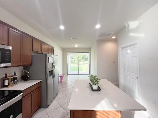 17504 Butterfly Pea Ct, Clermont, FL 34714 - kitchen featuring stainless steel appliances, a center island, light countertops, light tile patterned floors, and recessed lighting