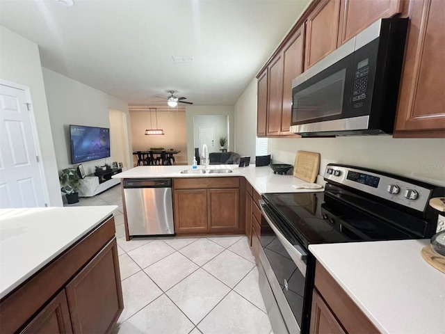 17504 Butterfly Pea Ct, Clermont, FL 34714 - kitchen with stainless steel appliances, open floor plan, a peninsula, ceiling fan, and light tile patterned floors