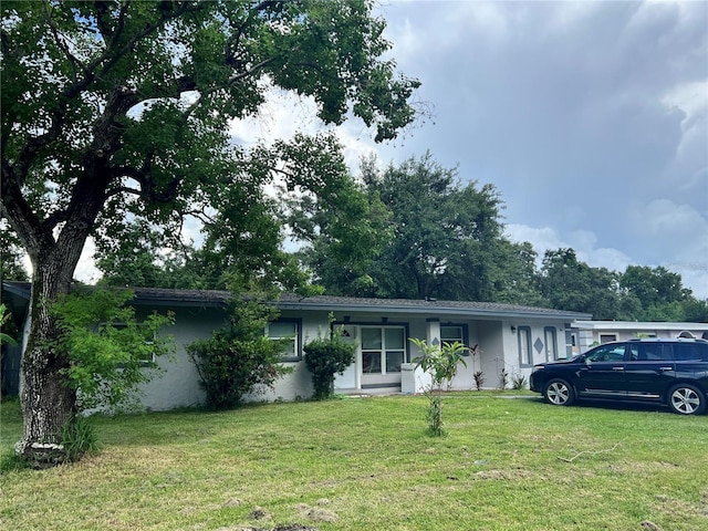 223 Hope Cir, Orlando, FL 32811 - ranch-style home featuring stucco siding and a front lawn