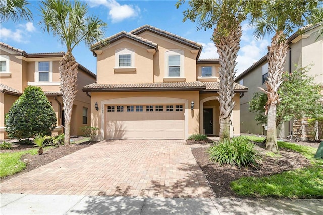 2108 Morocco Way, Kissimmee, FL 34747 - mediterranean / spanish home featuring decorative driveway, stucco siding, a garage, and a tiled roof
