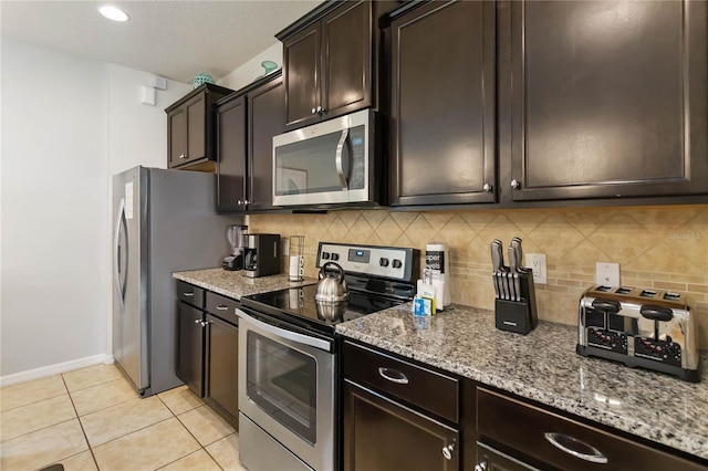 2108 Morocco Way, Kissimmee, FL 34747 - kitchen featuring stainless steel appliances, light stone counters, backsplash, and light tile patterned flooring