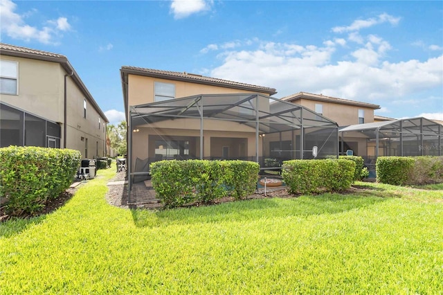 2108 Morocco Way, Kissimmee, FL 34747 - rear view of property featuring a yard, a tile roof, stucco siding, and a lanai