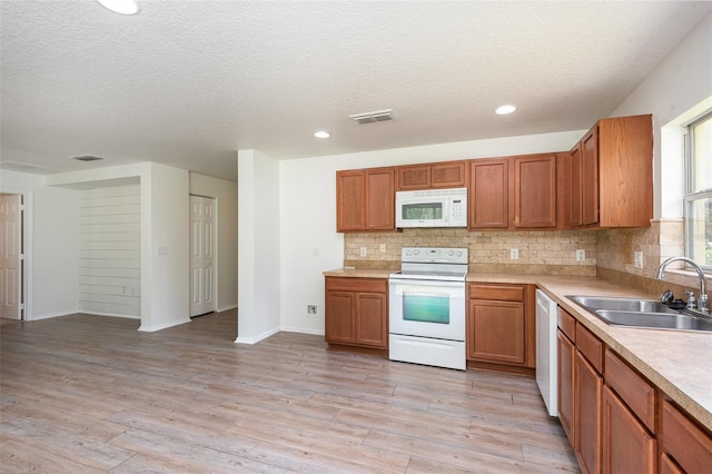 85 Levee Ln, Ormond Beach, FL 32174 - kitchen with white appliances, backsplash, a textured ceiling, light wood-style floors, and light countertops