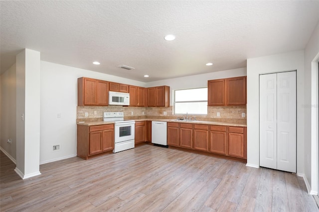85 Levee Ln, Ormond Beach, FL 32174 - kitchen with white appliances, tasteful backsplash, light countertops, light wood-style floors, and a textured ceiling