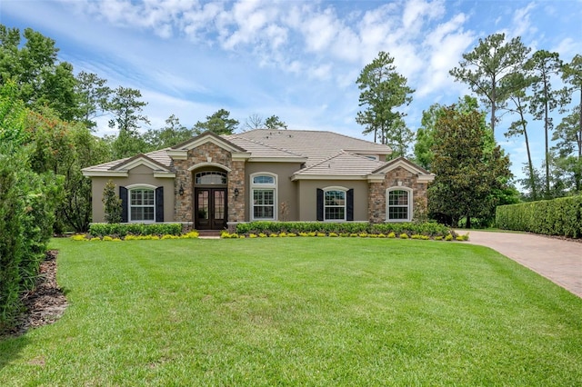 1462 Palm Bay Ct, Lake Mary, FL 32746 - view of front of property with stone siding, french doors, stucco siding, and a front lawn