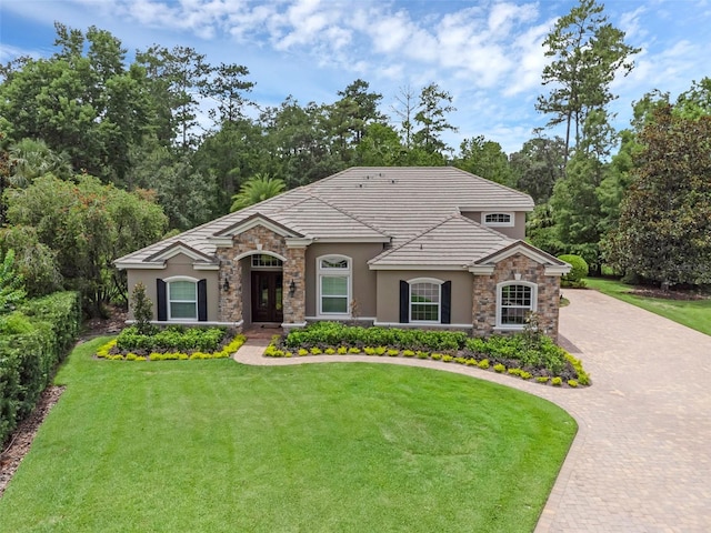 1462 Palm Bay Ct, Lake Mary, FL 32746 - view of front of property featuring stone siding, stucco siding, a front lawn, curved driveway, and a tile roof