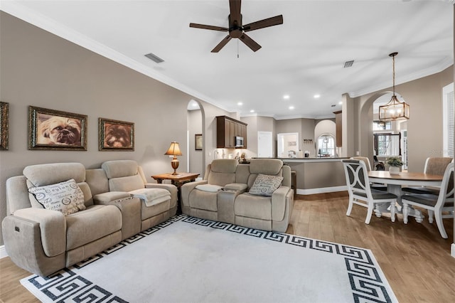 1462 Palm Bay Ct, Lake Mary, FL 32746 - living room featuring arched walkways, light wood-style flooring, a ceiling fan, crown molding, and recessed lighting