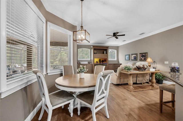 1462 Palm Bay Ct, Lake Mary, FL 32746 - dining area featuring crown molding, light wood finished floors, a chandelier, and ceiling fan