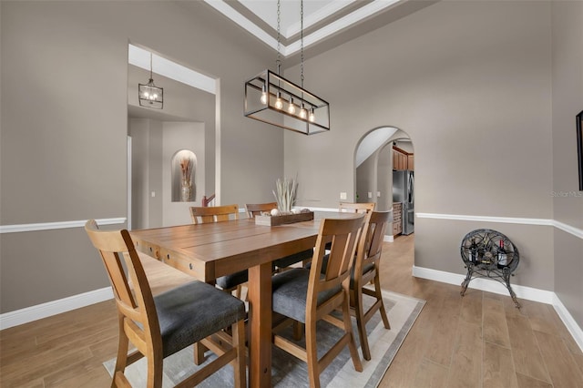 1462 Palm Bay Ct, Lake Mary, FL 32746 - dining space with arched walkways, light wood-style floors, and a towering ceiling