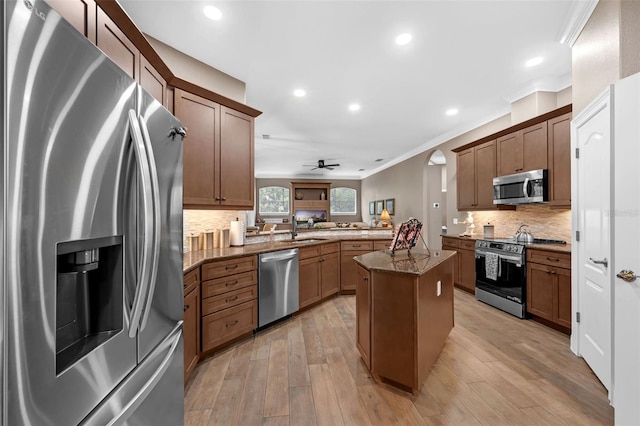 1462 Palm Bay Ct, Lake Mary, FL 32746 - kitchen featuring stainless steel appliances, a peninsula, crown molding, dark stone countertops, and tasteful backsplash