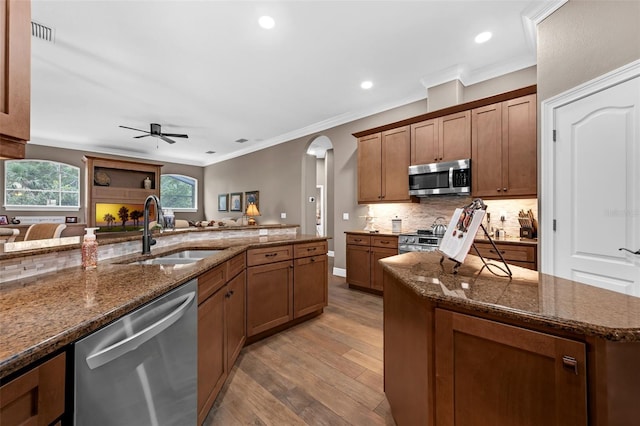 1462 Palm Bay Ct, Lake Mary, FL 32746 - kitchen featuring appliances with stainless steel finishes, arched walkways, light wood-style floors, ceiling fan, and ornamental molding