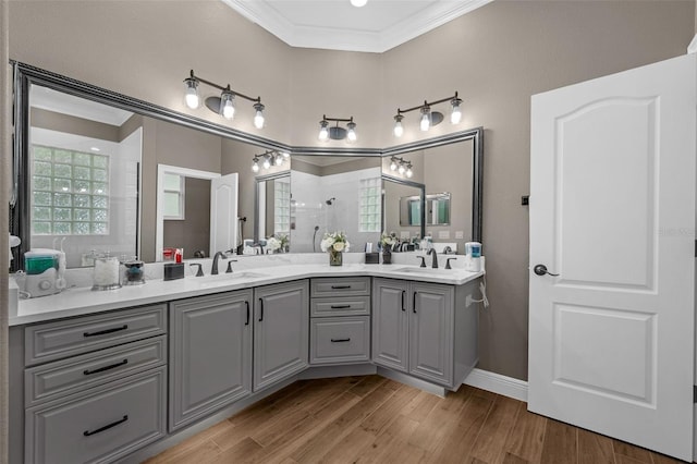 1462 Palm Bay Ct, Lake Mary, FL 32746 - bathroom featuring ornamental molding, double vanity, tiled shower, wood finished floors, and healthy amount of natural light