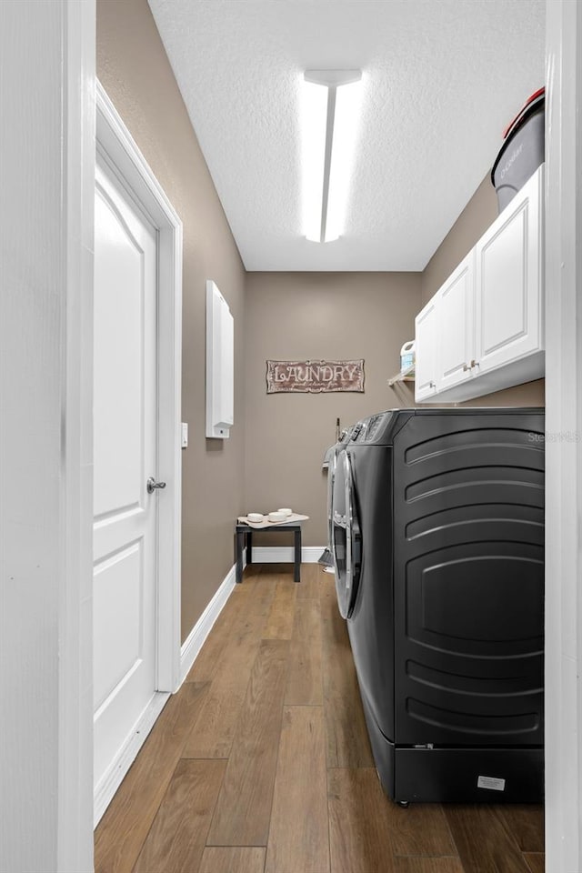 1462 Palm Bay Ct, Lake Mary, FL 32746 - laundry room with independent washer and dryer, cabinet space, hardwood / wood-style floors, and a textured ceiling