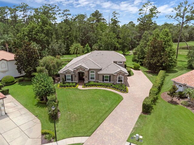 1462 Palm Bay Ct, Lake Mary, FL 32746 - view of front of property featuring stone siding, a front lawn, stucco siding, and a tile roof