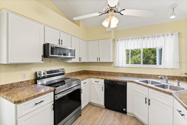 956 Chula Ct, Lady Lake, FL 32159 - kitchen with stainless steel appliances, lofted ceiling, a ceiling fan, white cabinets, and light wood-style floors