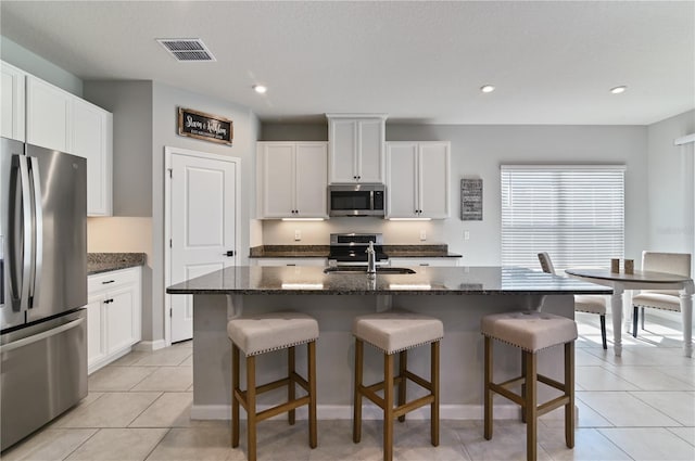 410 Winter Bliss Ln, Mount Dora, FL 32757 - kitchen with appliances with stainless steel finishes, a breakfast bar, dark stone counters, and recessed lighting