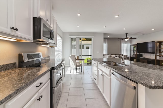 410 Winter Bliss Ln, Mount Dora, FL 32757 - kitchen with stainless steel appliances, white cabinets, light tile patterned flooring, a ceiling fan, and a kitchen island with sink