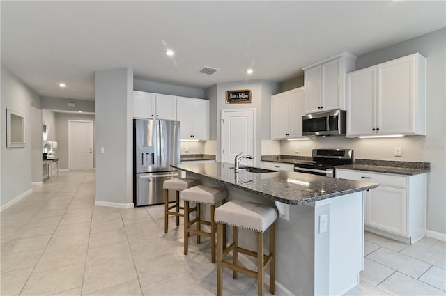 410 Winter Bliss Ln, Mount Dora, FL 32757 - kitchen featuring appliances with stainless steel finishes, recessed lighting, a breakfast bar, light tile patterned floors, and a kitchen island with sink