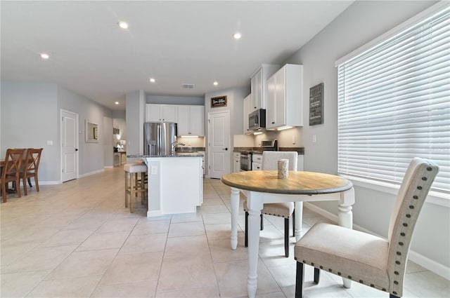 410 Winter Bliss Ln, Mount Dora, FL 32757 - kitchen featuring stainless steel appliances, a kitchen island with sink, white cabinetry, recessed lighting, and light tile patterned flooring