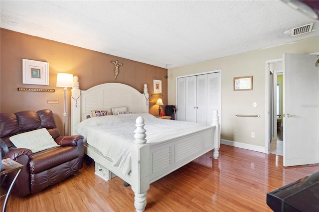 7022 Talbot Dr, Orlando, FL 32819 - bedroom with light wood-type flooring, a closet, and a textured ceiling
