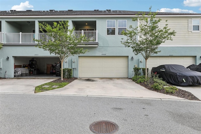 10009 Randal Walk St, Orlando, FL 32832 - view of property with a garage, stucco siding, a balcony, and concrete driveway