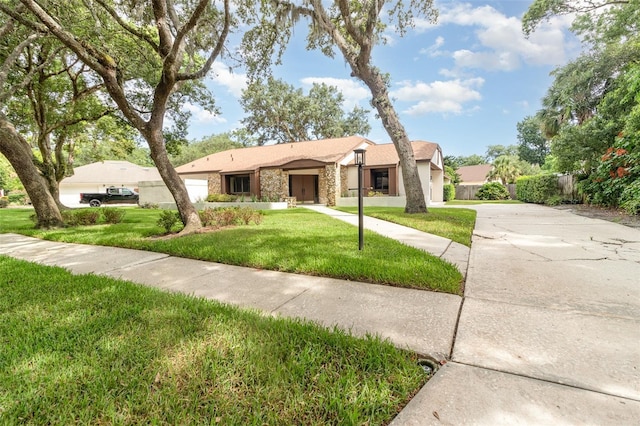 1424 Mt Laurel Dr, Winter Springs, FL 32708 - view of front of house featuring stone siding, a front yard, concrete driveway, and stucco siding