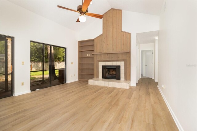 1424 Mt Laurel Dr, Winter Springs, FL 32708 - unfurnished living room with high vaulted ceiling, a tiled fireplace, light wood-style flooring, and a ceiling fan