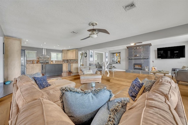 7801 Georgeann St, Winter Park, FL 32792 - living area with a ceiling fan, a textured ceiling, light wood finished floors, recessed lighting, and a fireplace
