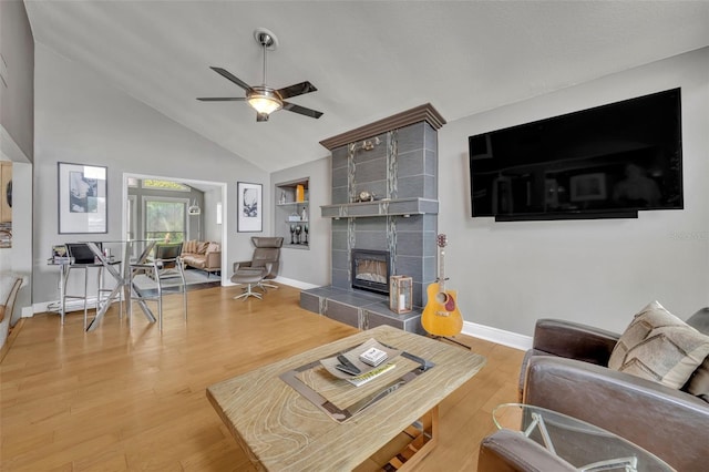 7801 Georgeann St, Winter Park, FL 32792 - living room with ceiling fan, a tiled fireplace, wood finished floors, and high vaulted ceiling