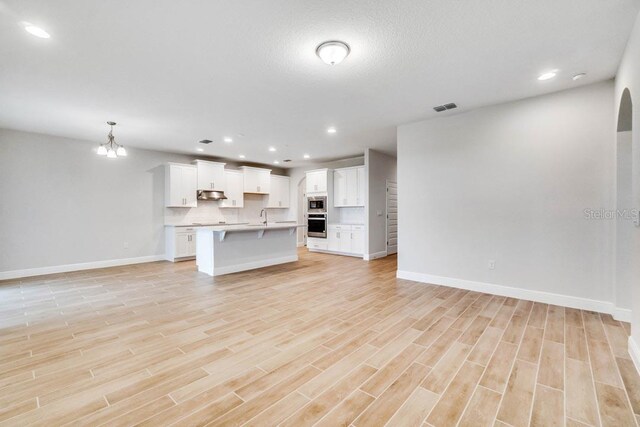 16146 Point Rock Dr, Winter Garden, FL 34787 - unfurnished living room with light wood-style flooring, a chandelier, and recessed lighting