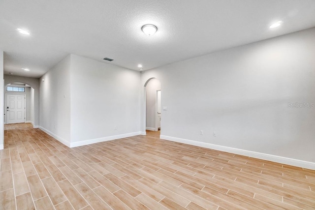 16146 Point Rock Dr, Winter Garden, FL 34787 - unfurnished room with arched walkways, light wood finished floors, and recessed lighting