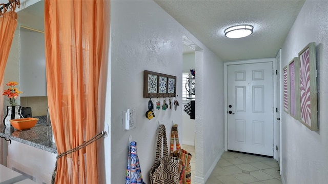 145 N Halifax Ave Unit 705, Daytona Beach, FL 32118 - entryway with a textured ceiling, light tile patterned floors, and a textured wall