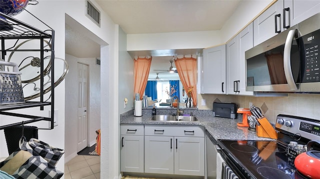 145 N Halifax Ave Unit 705, Daytona Beach, FL 32118 - kitchen featuring stainless steel appliances, ceiling fan, light stone counters, light tile patterned floors, and tasteful backsplash