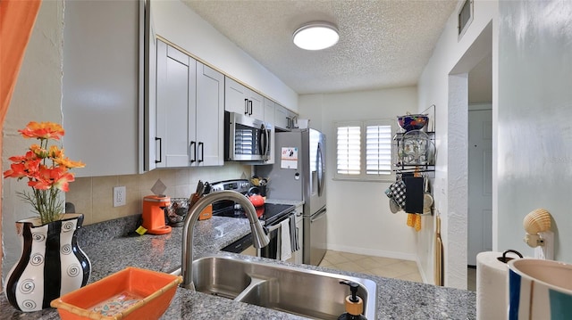 145 N Halifax Ave Unit 705, Daytona Beach, FL 32118 - kitchen with appliances with stainless steel finishes, a textured ceiling, light tile patterned floors, and tasteful backsplash