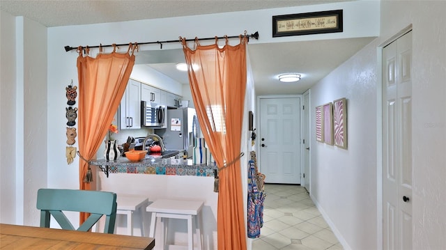 145 N Halifax Ave Unit 705, Daytona Beach, FL 32118 - kitchen featuring appliances with stainless steel finishes, dark countertops, and light tile patterned floors