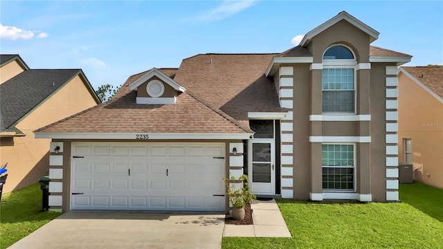 2235 Meadowmouse St, Orlando, FL 32837 - view of front of property with a shingled roof, concrete driveway, stucco siding, a front lawn, and an attached garage
