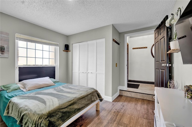 2235 Meadowmouse St, Orlando, FL 32837 - bedroom featuring a textured ceiling, light wood-style flooring, and a closet