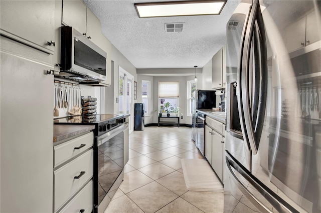 2235 Meadowmouse St, Orlando, FL 32837 - kitchen with appliances with stainless steel finishes, a textured ceiling, and light tile patterned floors