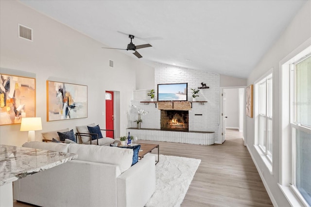 370 Hand Ave, Ormond Beach, FL 32174 - living room with lofted ceiling, a fireplace, wood finished floors, and ceiling fan