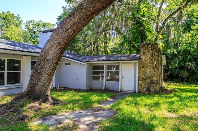 370 Hand Ave, Ormond Beach, FL 32174 - view of front of property featuring a front lawn, stucco siding, and a chimney