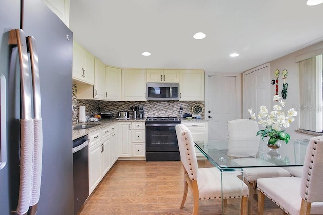545 Mystic Wood St, Casselberry, FL 32707 - kitchen with stainless steel appliances, light wood-style floors, decorative backsplash, recessed lighting, and light stone counters