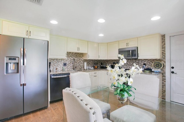 545 Mystic Wood St, Casselberry, FL 32707 - kitchen featuring stainless steel appliances, cream cabinets, decorative backsplash, recessed lighting, and light stone counters