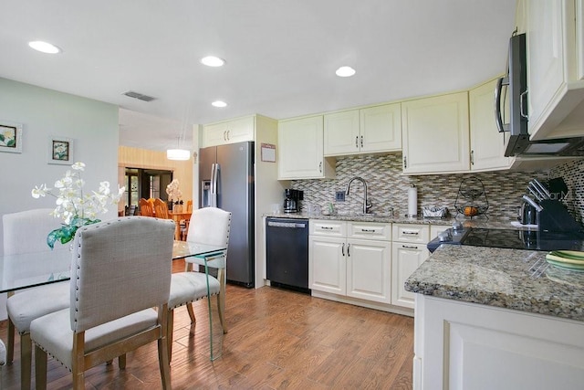 545 Mystic Wood St, Casselberry, FL 32707 - kitchen featuring dishwashing machine, stainless steel fridge, light stone countertops, backsplash, and black microwave