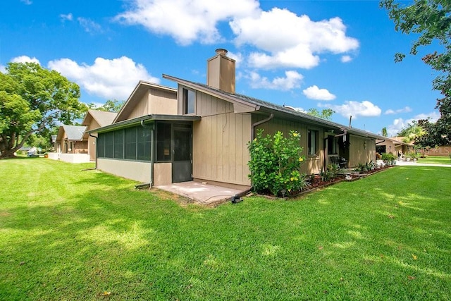 545 Mystic Wood St, Casselberry, FL 32707 - rear view of property with a chimney, a sunroom, and a lawn