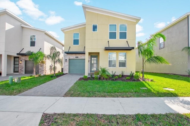 8982 Cabot Cliffs Dr, Davenport, FL 33896 - contemporary house with stucco siding, decorative driveway, a front yard, and an attached garage