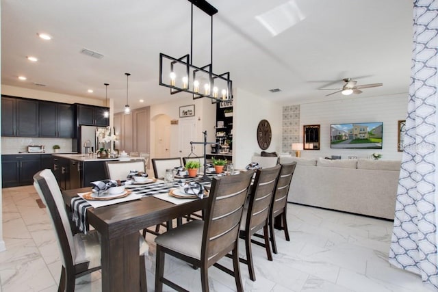 8982 Cabot Cliffs Dr, Davenport, FL 33896 - dining area featuring a ceiling fan, light marble finish flooring, recessed lighting, and arched walkways