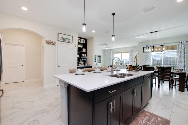 8982 Cabot Cliffs Dr, Davenport, FL 33896 - kitchen with light marble finish flooring, stainless steel dishwasher, recessed lighting, light countertops, and arched walkways